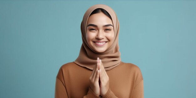 이드 무바라크 인사말 몸짓 갈색 스웨터에 웃는 아름다운 아시아 이슬람 여성