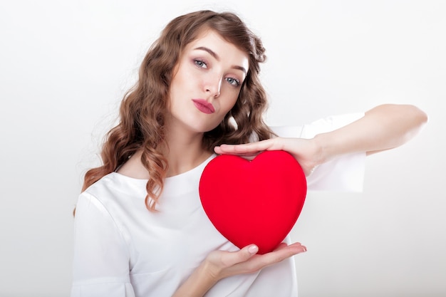 Smiling beautiful curly woman with heart shaped air balloons for St. Valentine's Day