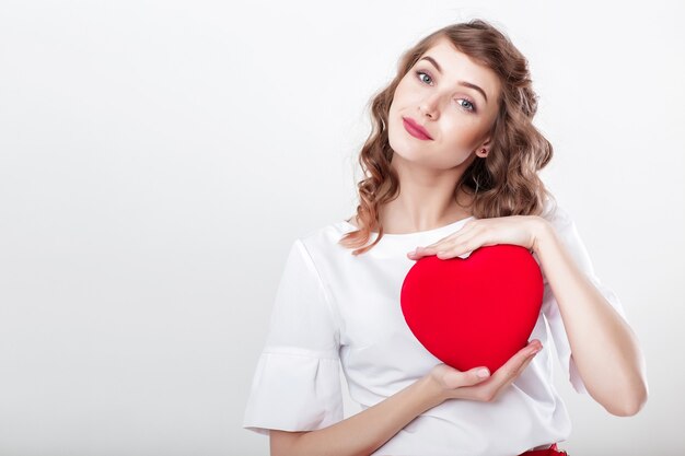 Smiling beautiful curly woman with heart shaped air balloons for St. Valentine's Day