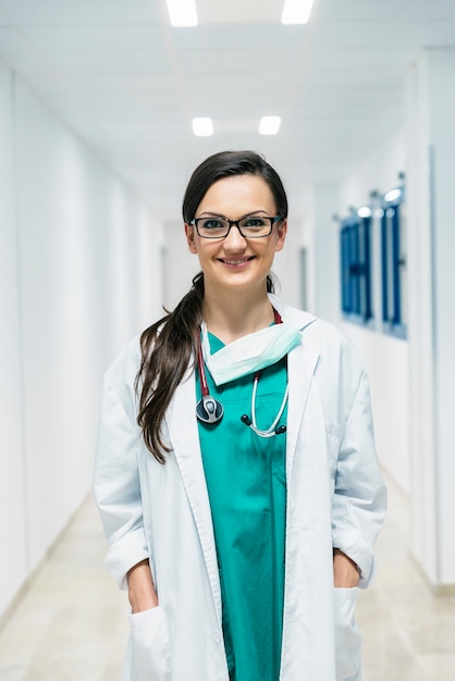 Smiling beautiful doctor at hospital. Standing.