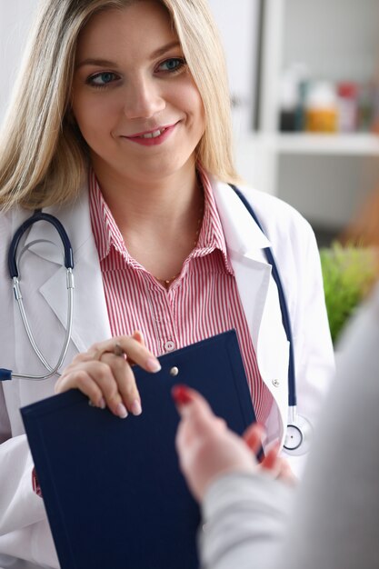 Smiling beautiful female doctor holding clipboard