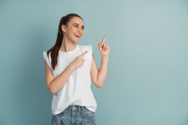 La bella ragazza sorridente si presenta nello spazio vuoto