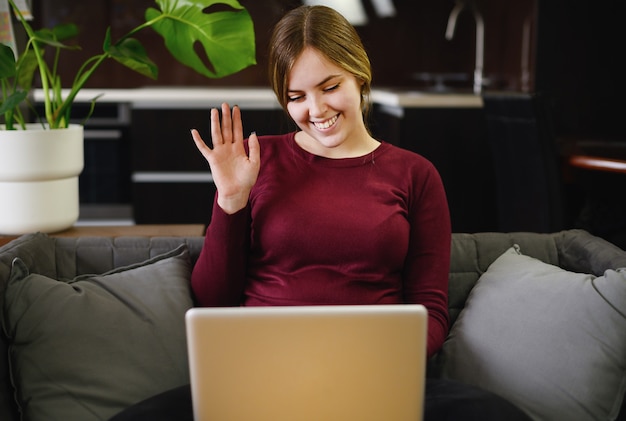 Sorridente bella giovane donna utilizzando il computer a casa. foto di alta qualità