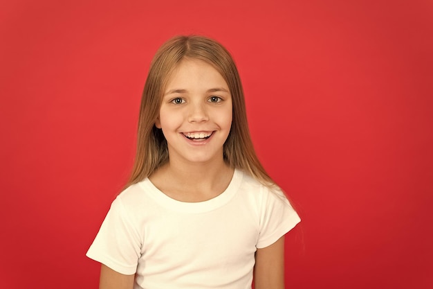Smiling beauty brilliant smile concept girl happy smiling face over red background emotional kid cute smiling face sincere emotion cheerful adorable girl smiling positive and optimistic