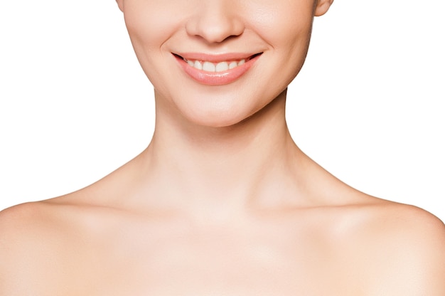 Smiling beauty. Cropped image of beautiful young shirtless woman smiling while isolated on white background