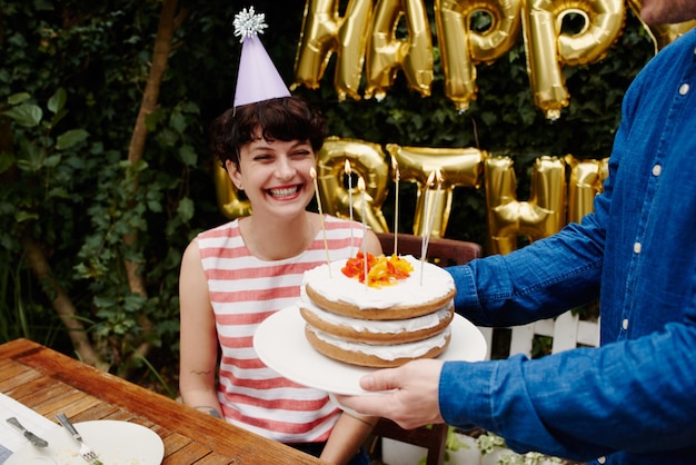 外で座っている笑顔の誕生日の女性