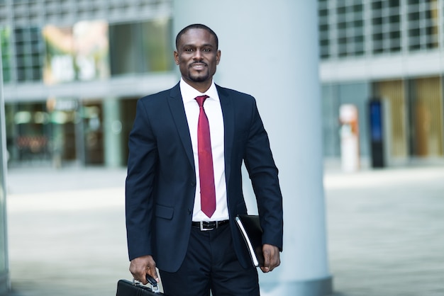 Smiling black businessman going at his office