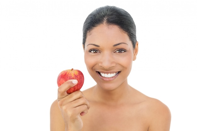 赤いリンゴを持つ黒い髪のモデルを笑顔