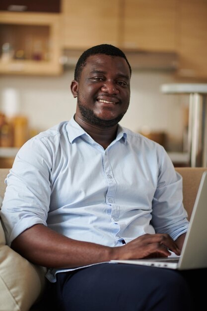 Smiling Black Man Working on Laptop