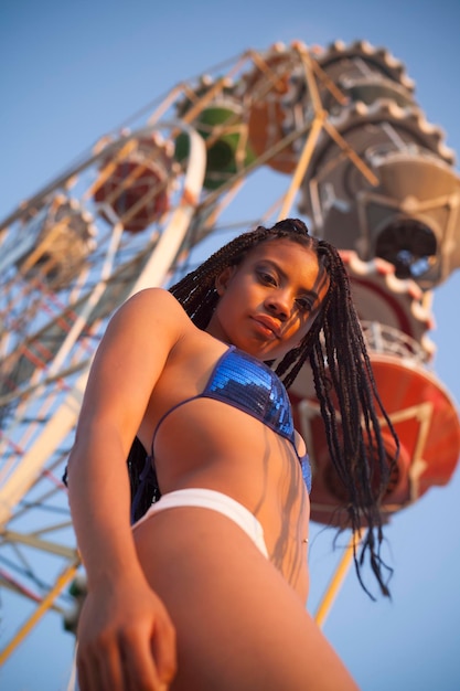 Smiling black woman in bikini in amusement park