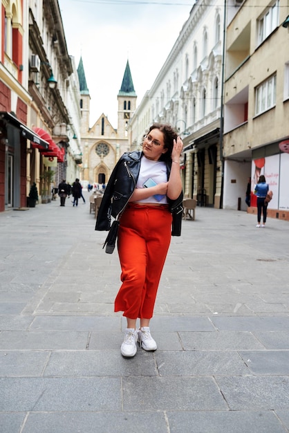 Smiling black woman in the stylist clothes and glasses enjoying sunny day College girl walking over the city