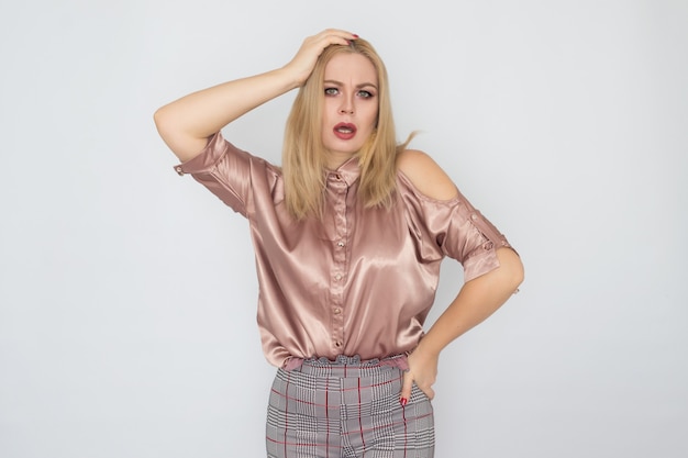 Smiling blonde business woman in pink blouse over white background