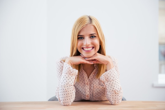 Smiling blonde businesswoman sitting at the desk