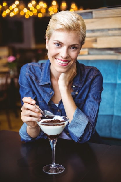 Smiling blonde eating a creamy chocolate 