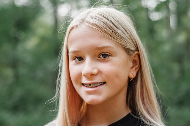 Smiling blonde girl with orthodontic braces