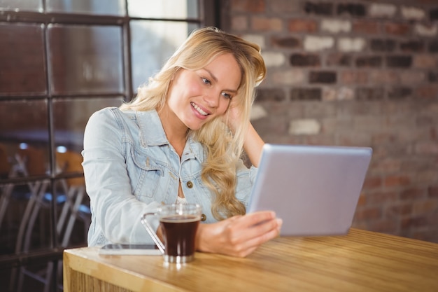 Smiling blonde holding tablet computer