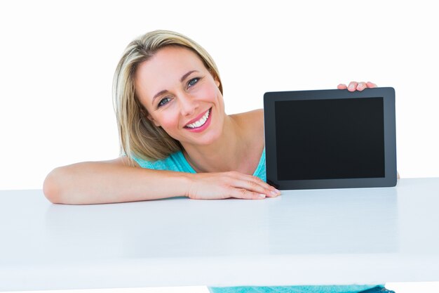 Smiling blonde posing and showing tablet