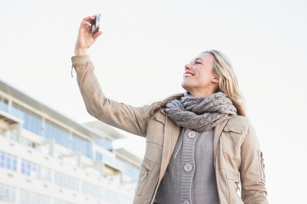 Smiling blonde posing and taking a selfie