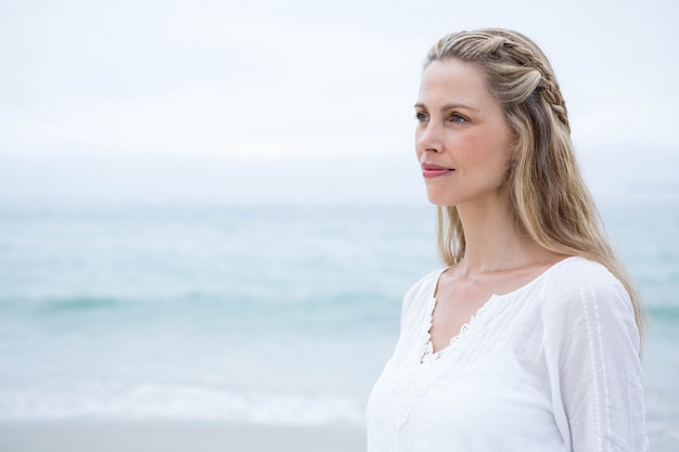 Smiling blonde standing by the sea