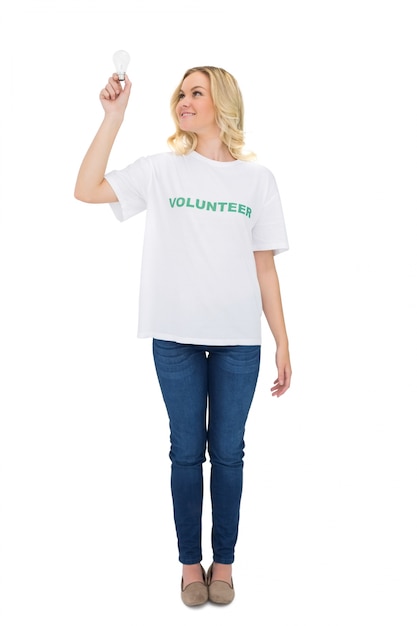 Smiling blonde volunteer holding light bulb