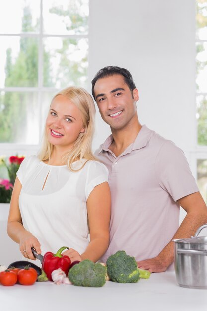 Smiling blonde woman cooking with her husband