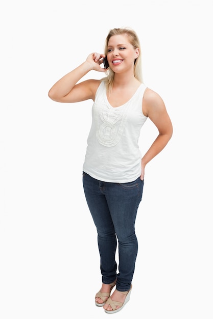 Smiling blonde woman holding her mobile phone