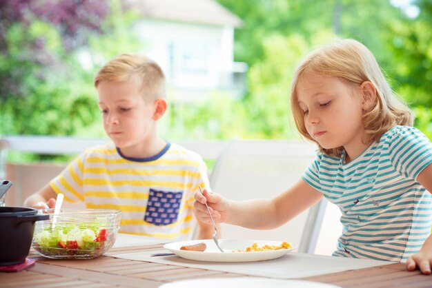 写真 妹と一緒に家で食べている笑顔の男の子