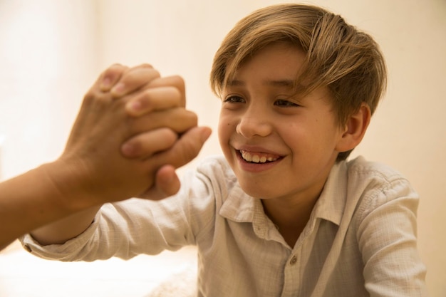 Foto ragazzo sorridente che si tiene per mano