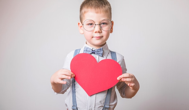 Smiling boy holding a red heart