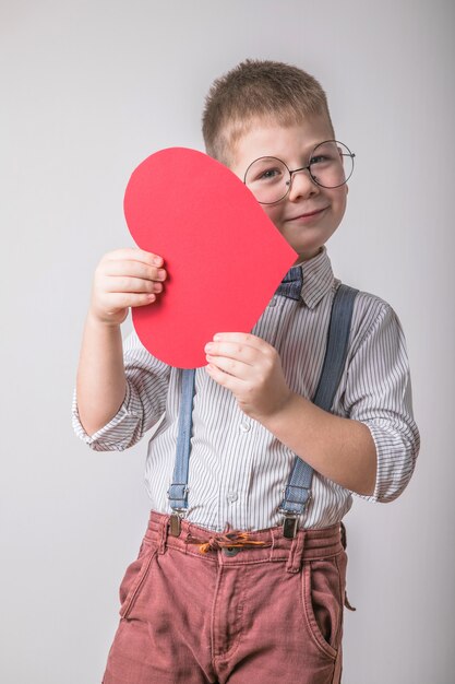 Smiling boy holding a red heart