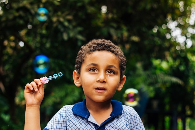 Smiling boy playing soap bubble