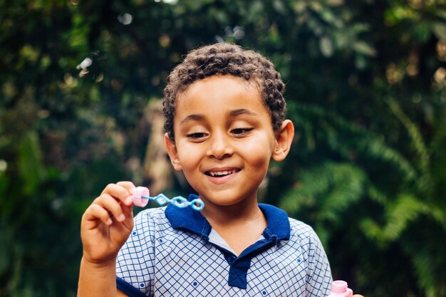 Smiling boy playing soap bubble