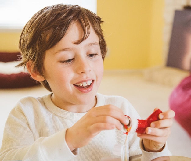 Foto ragazzo sorridente che gioca con le decorazioni natalizie