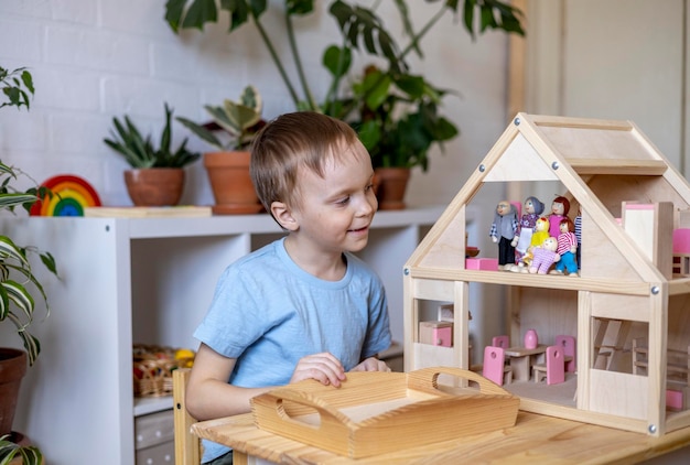 Photo smiling boy playing with model house at home