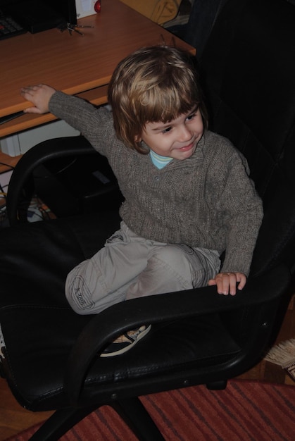 Smiling boy sitting on chair at home