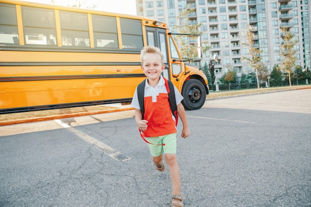 Photo smiling boy standing by bus