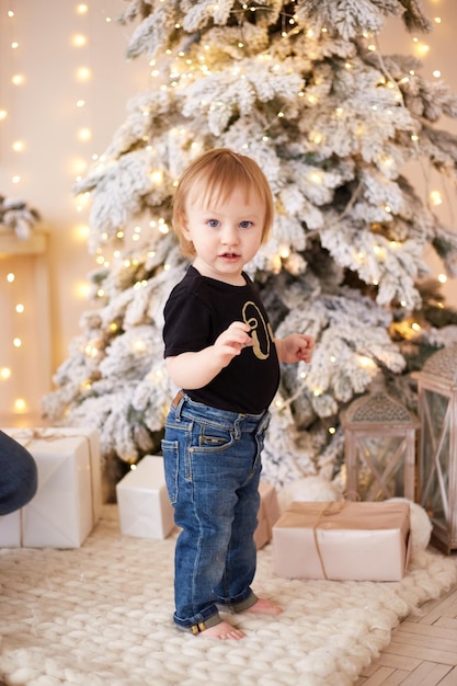 Smiling boy standing near christmas tree Happy new year and merry Christmas