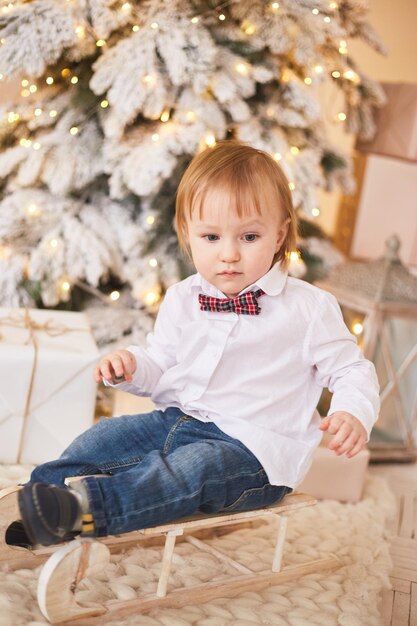 Smiling boy standing near christmas tree Happy new year and merry Christmas