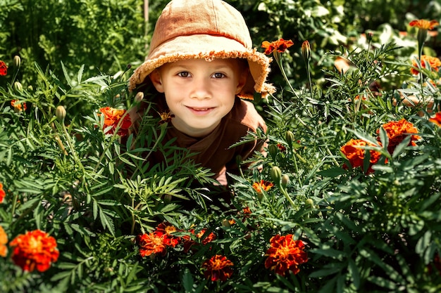 smiling boy stands in flowers