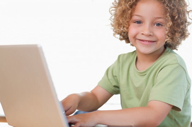 Photo smiling boy using a notebook