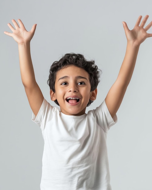 A smiling boy with his hands up