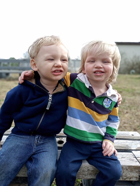 Photo smiling boys sitting on wood