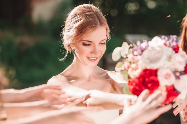 彼女の友人に結婚式の花束を渡す笑顔の花嫁