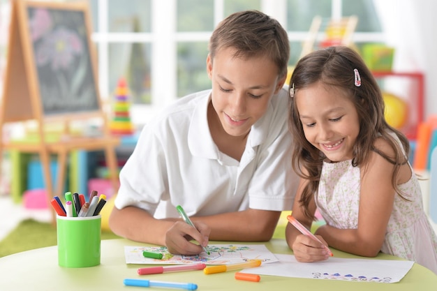 Smiling brother and sister drawing together