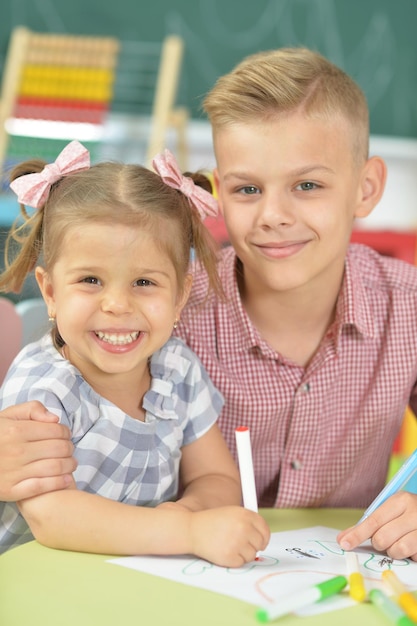 Smiling brother and sister drawing with felt pens