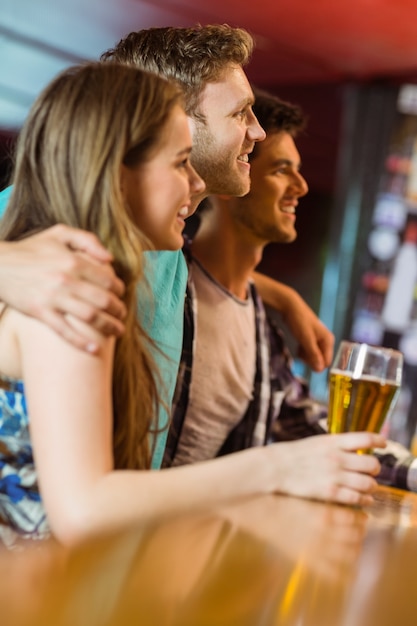 Smiling brown hair standing with arm around his friends