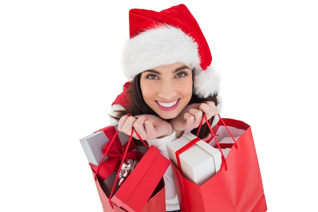 Smiling brunette holding shopping bags full of gifts 