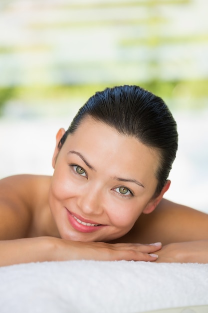 Smiling brunette lying on massage table