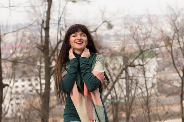 Smiling brunette woman with long hair at the street. Lviv, Ukraine