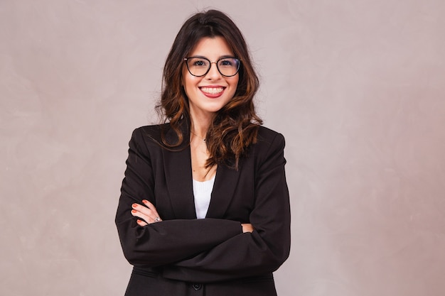 Smiling brunette woman without glasses posing with arms crossed and looking at camera.